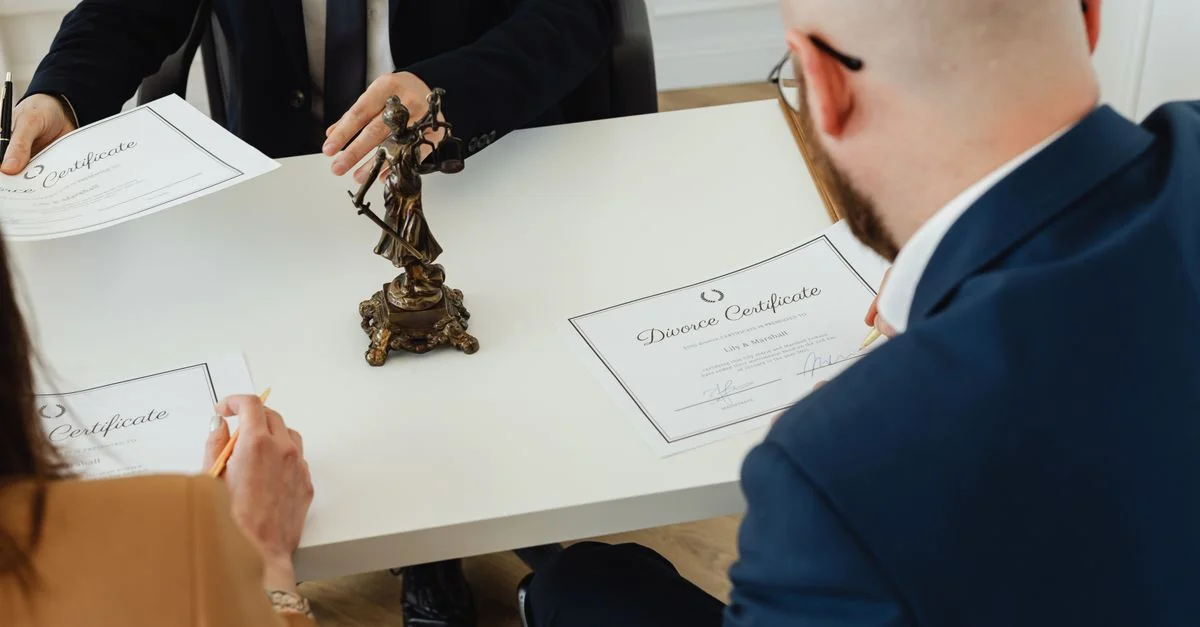Un cadre professionnel avec un accent sur la signature de documents de divorce dans un environnement de bureau.