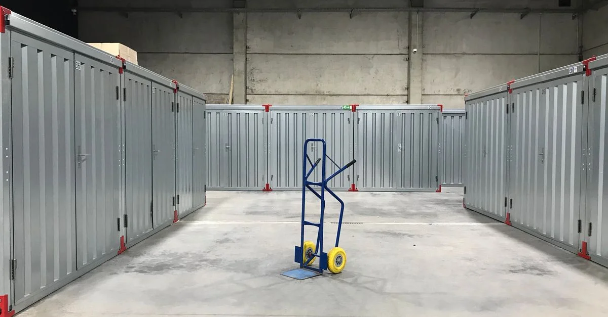 Unités de stockage en acier dans un entrepôt industriel avec un chariot bleu au centre, idéal pour la logistique.