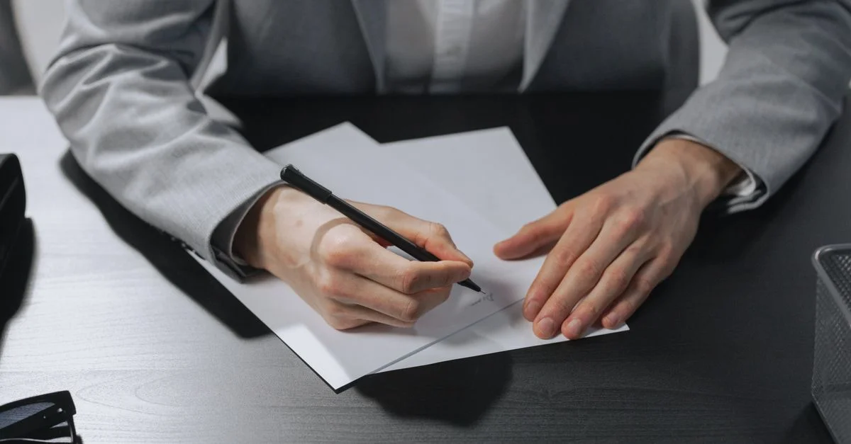 Des mains professionnelles signant un document dans un cadre de bureau à des fins professionnelles.