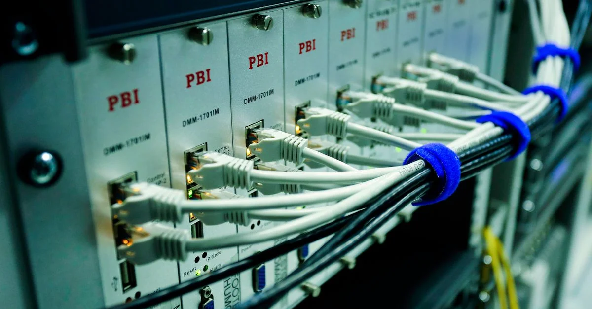 Gros plan de câbles Ethernet connectés à un panneau de commutateur réseau dans un centre de données.