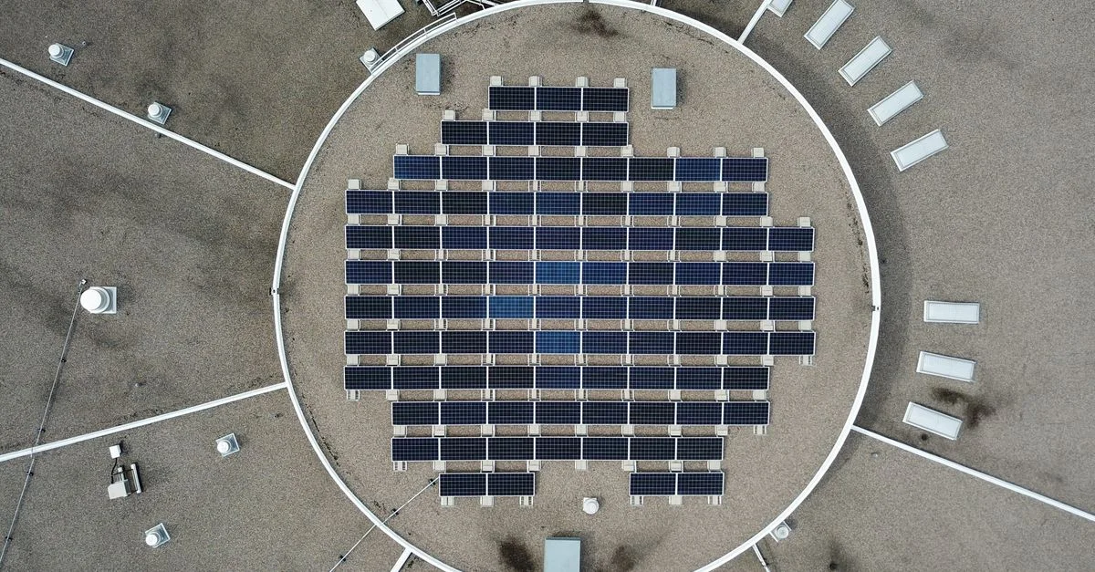 Photo aérienne d'un réseau de panneaux solaires sur un toit, maximisant la production d'énergie renouvelable.