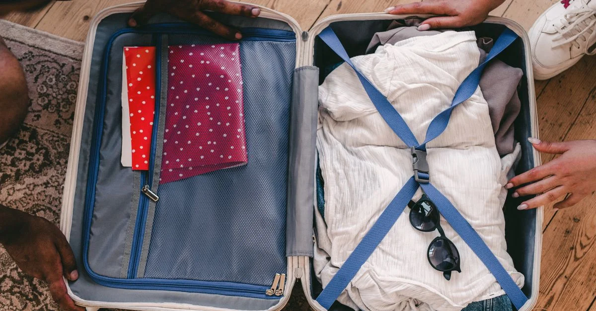 Une valise ouverte soigneusement remplie de vêtements et d'éléments essentiels de voyage, prête pour un voyage.