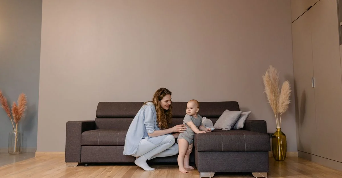 Une mère et son tout-petit partagent des moments ludiques sur un canapé confortable dans le salon.