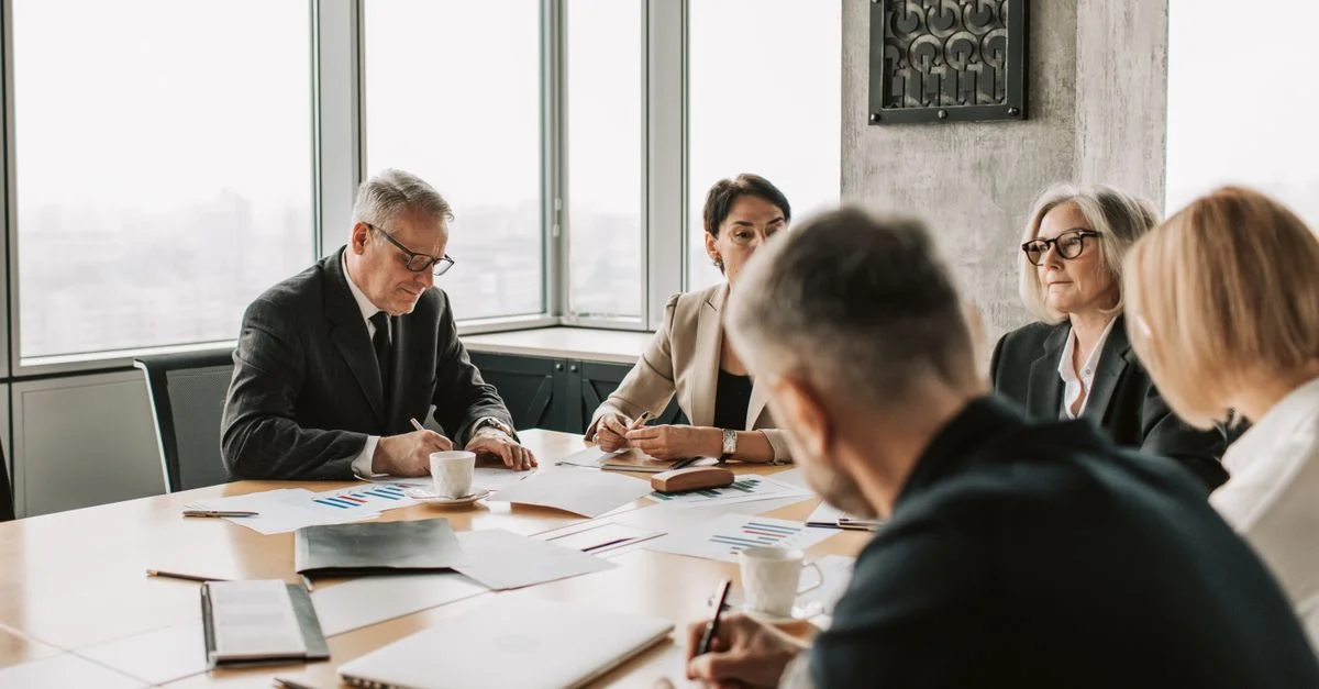 Des professionnels du business engagés dans une réunion collaborative autour d'une table de conférence.
