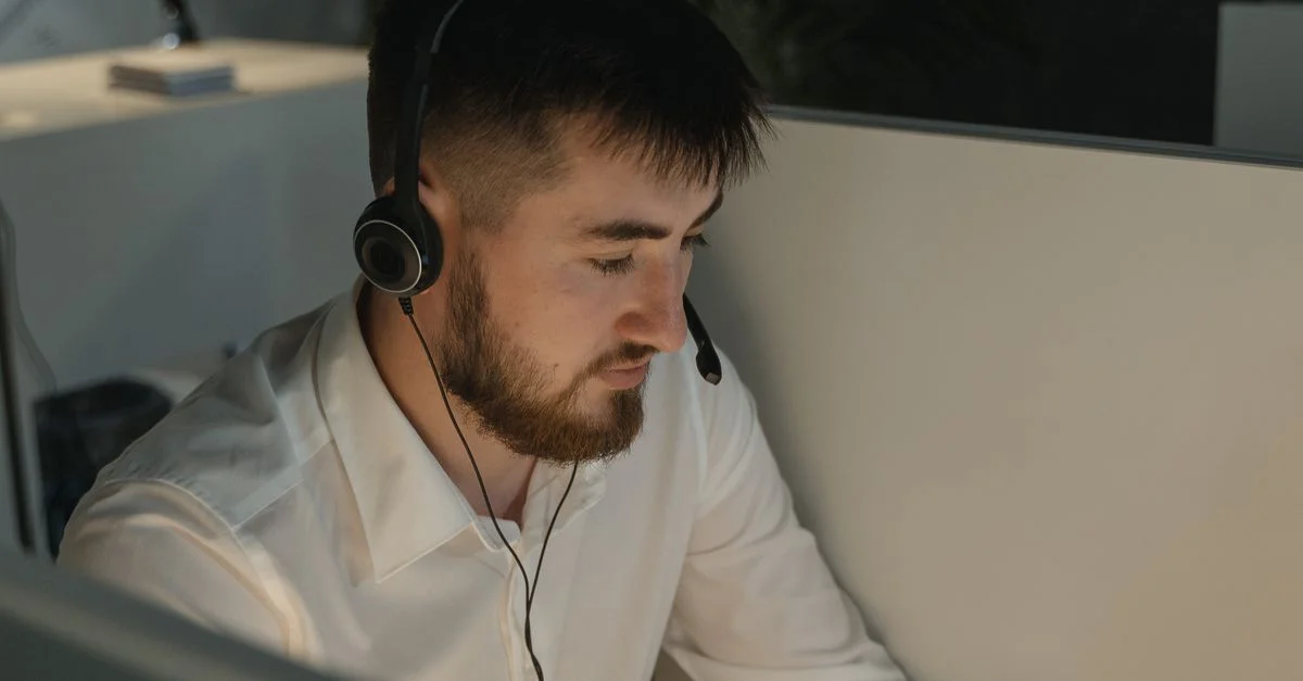 Un homme barbu avec un casque travaillant attentivement dans un centre d'appels.