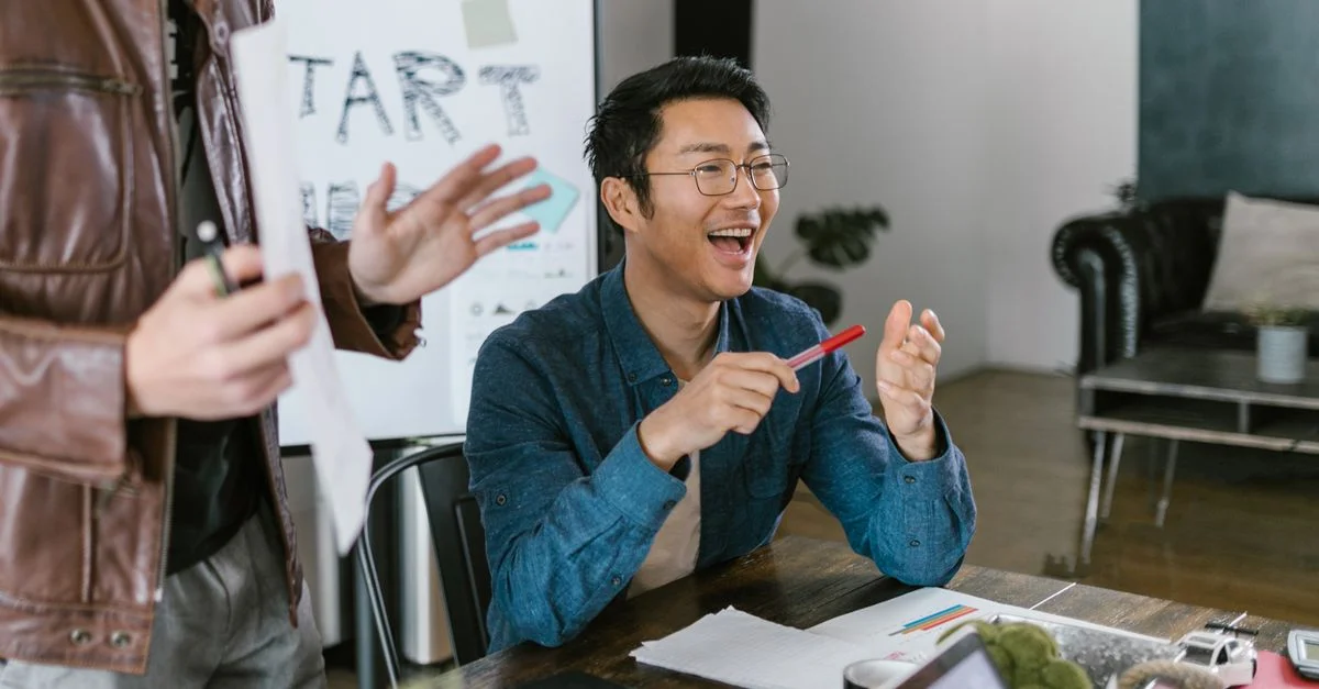 Membres de l'équipe engagés dans une réunion de bureau animée discutant des idées de startup et de l'innovation.