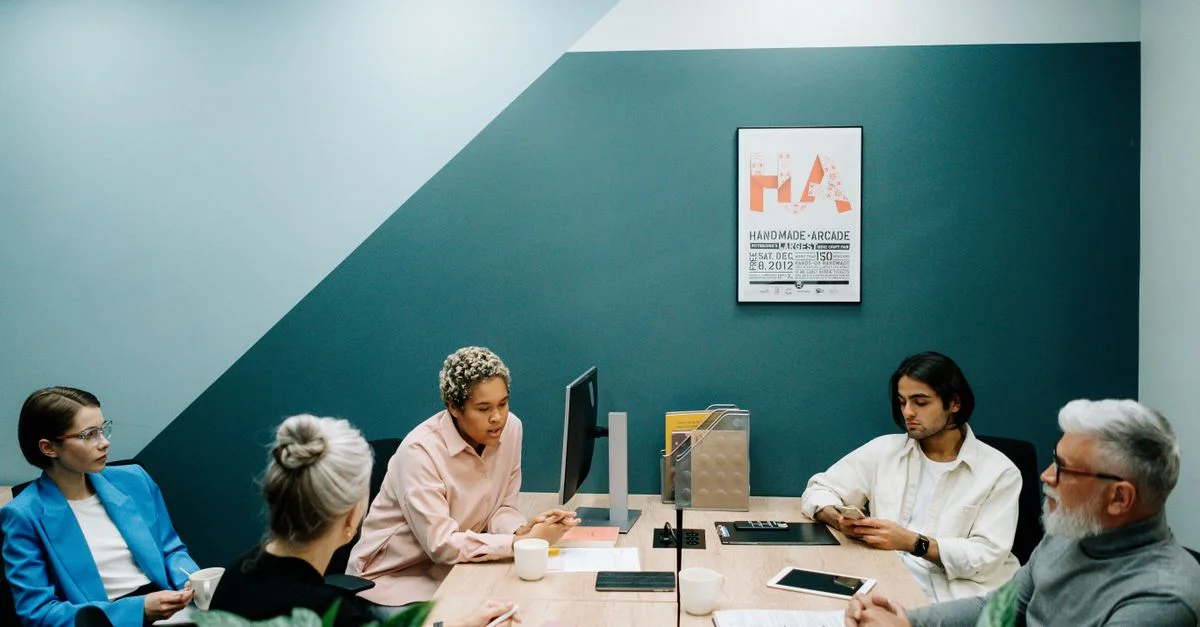 Un groupe de professionnels divers engagés dans une réunion d'équipe dans un environnement de bureau contemporain.