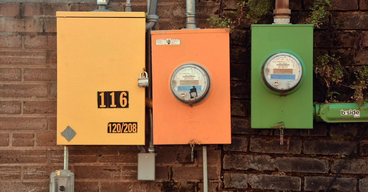 Trois compteurs utilitaires vibrants sur un mur en brique mettant en valeur le design industriel urbain à Texarkana, Texas.