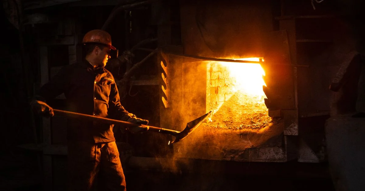 Ouvrier de la classe ouvrière gérant un four dans un environnement industriel.