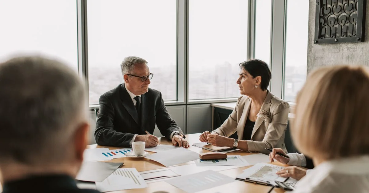 Des professionnels des affaires engagés dans une réunion stratégique dans un bureau moderne avec lumière naturelle.