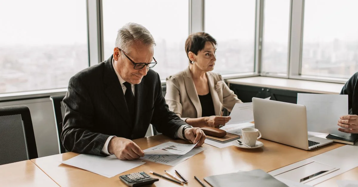 Réunion d'entreprise avec des professionnels discutant de documents dans un bureau moderne.