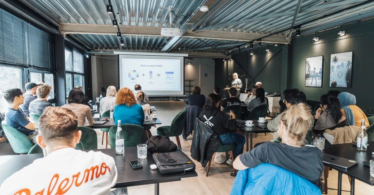 Un groupe divers participant à un atelier éducatif à l'intérieur, concentré sur une présentation.