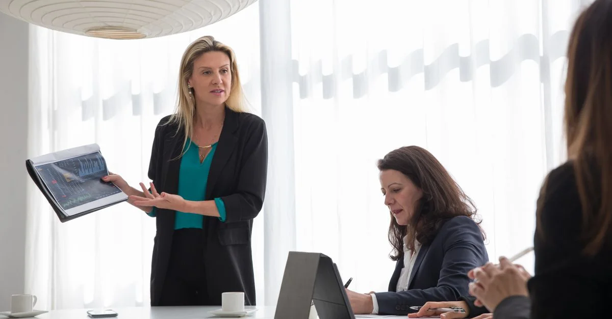 Femme d'affaires présentant des données lors d'une réunion d'entreprise à l'intérieur.