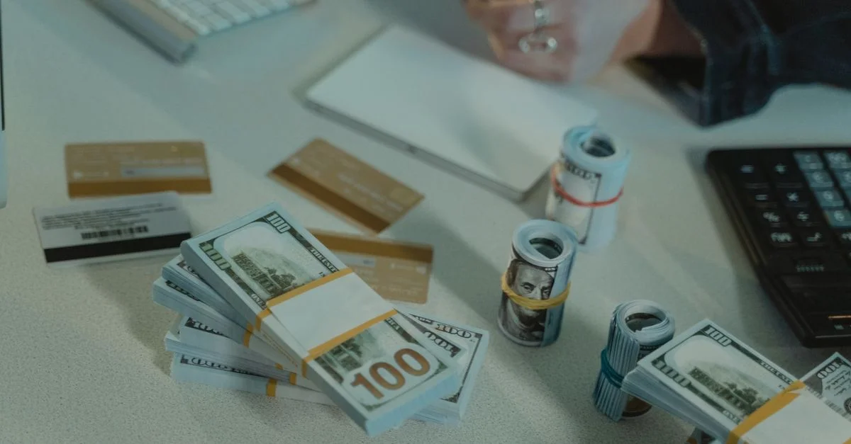 Gros plan sur des billets en dollars et des cartes de crédit sur un bureau, symbolisant des transactions financières.
