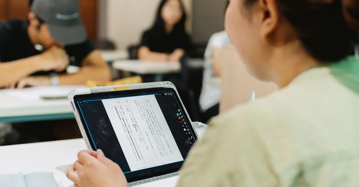 Des élèves dans une classe japonaise utilisent une tablette pour l'apprentissage numérique, favorisant ainsi l'éducation moderne.