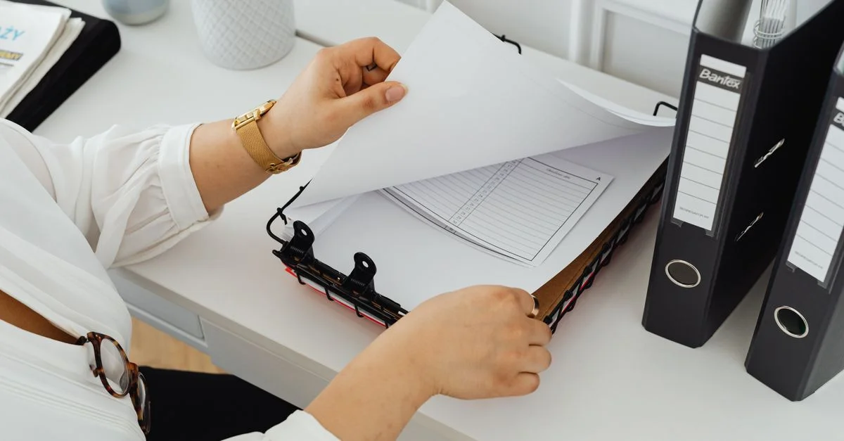 Professionnel des affaires triant des documents dans un bureau moderne.