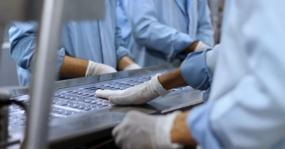 Ouvriers dans une usine pharmaceutique conditionnant des comprimés à Islamabad.