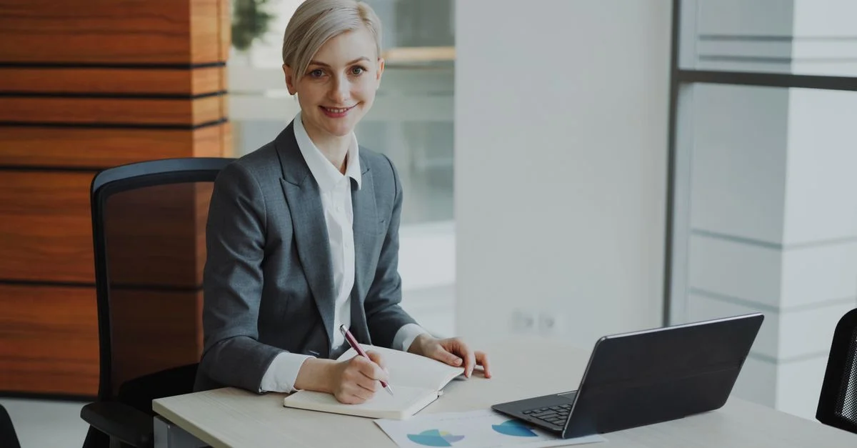 Femme d'affaires confiante prenant des notes dans un environnement de bureau contemporain.