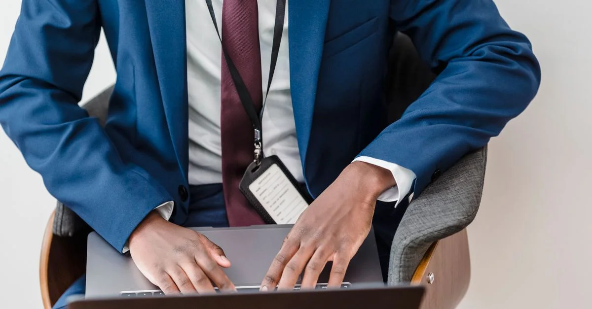 Vue de dessus d'un homme d'affaires en costume bleu utilisant un ordinateur portable dans un bureau moderne.