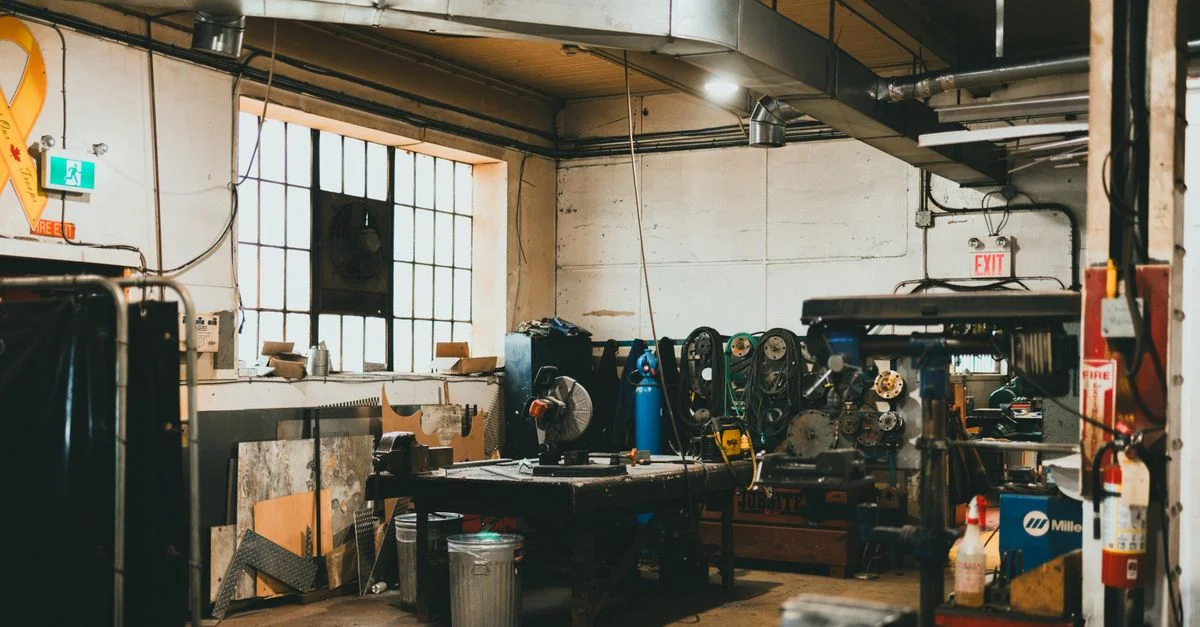 Atelier industriel intérieur aux tons chauds avec outils et équipement.
