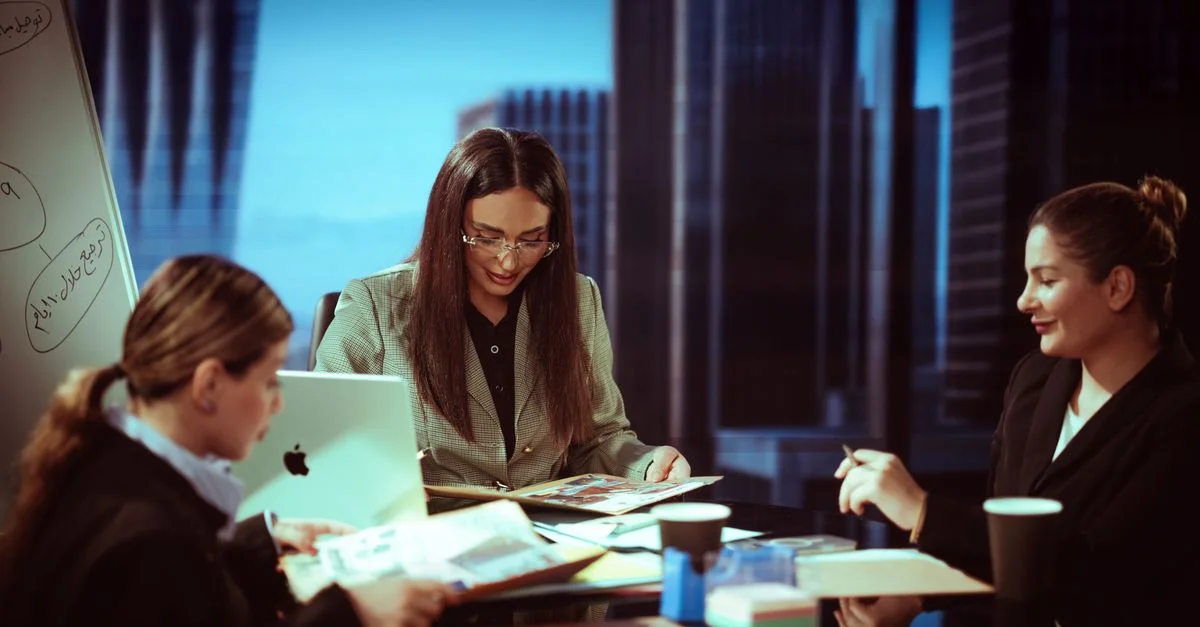 Trois femmes d'affaires engagées dans une réunion dans un bureau contemporain.
