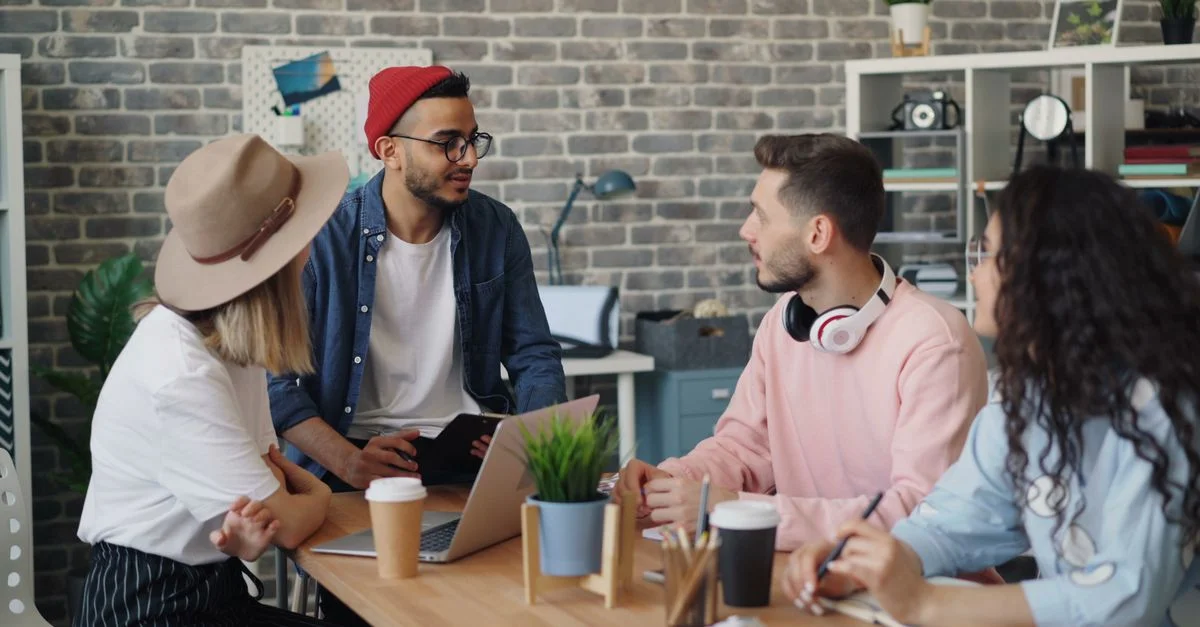 Jeune équipe créative discutant d'idées de projet dans un cadre de bureau moderne.