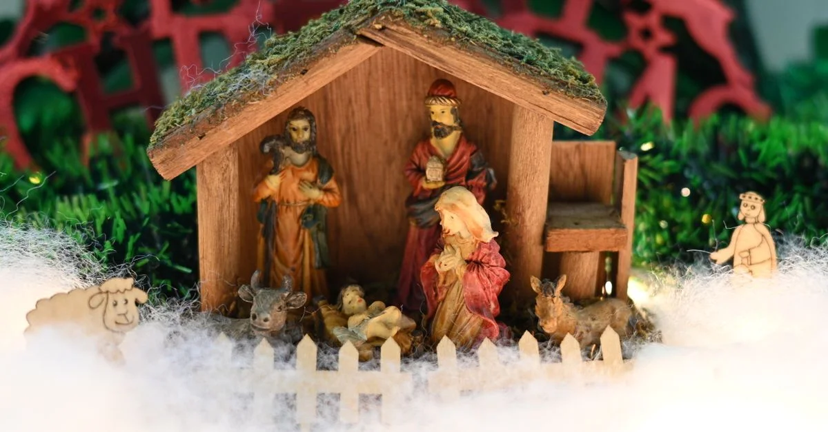 Gros plan d'une crèche traditionnelle en bois avec des figurines représentant la naissance de Jésus.