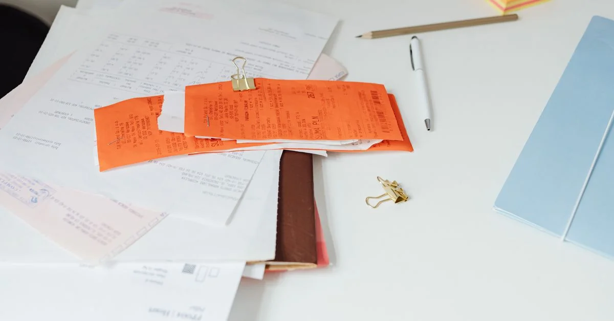 Gros plan sur un bureau bien rangé avec des reçus, des documents et des fournitures de bureau pour l'organisation professionnelle.