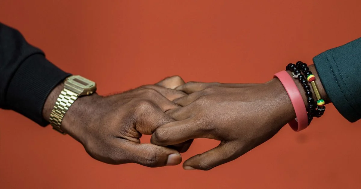 Deux mains afro-américaines se tenant l'une l'autre, symbolisant l'unité et l'amour.