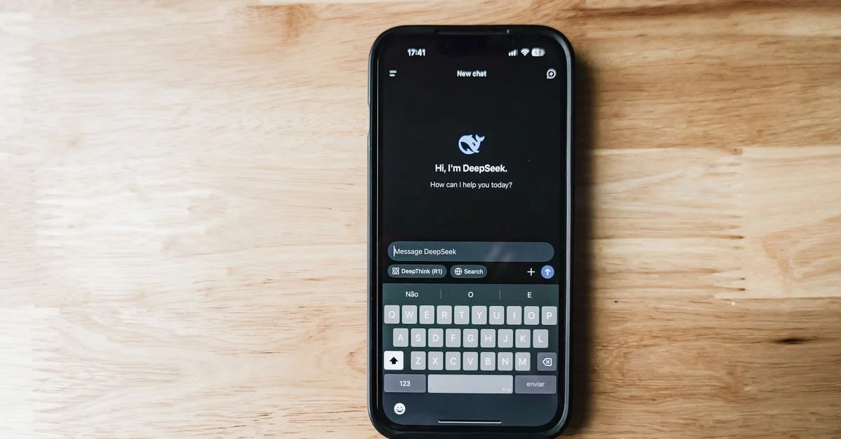 Un smartphone sur une table en bois montrant une interface de chatbot IA appelée DeepSeek.