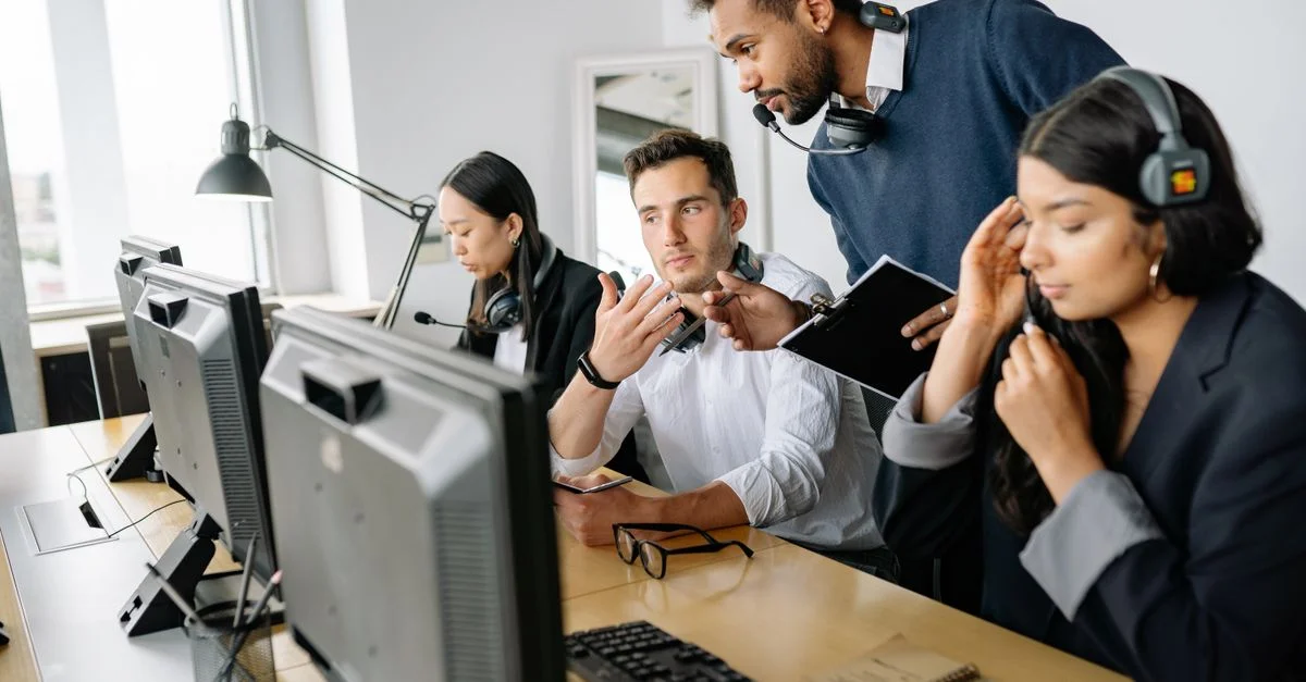Une équipe diversifiée d'agents de centre d'appels collaborant dans un environnement de bureau moderne.