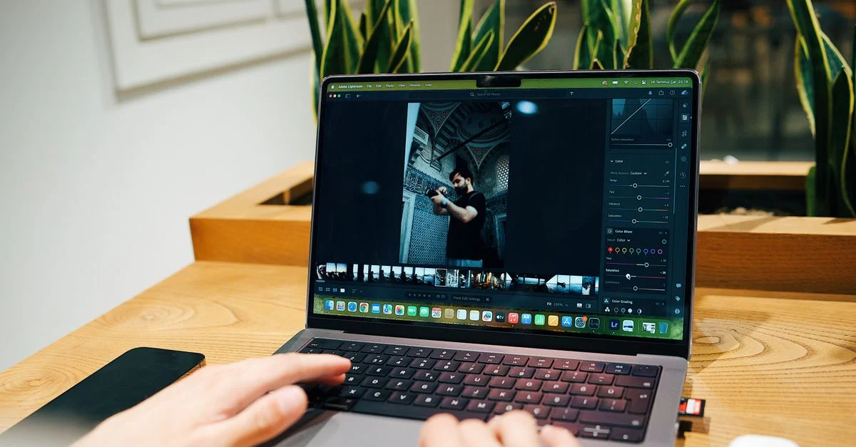 Un photographe édite des images sur un ordinateur portable dans un bureau moderne.