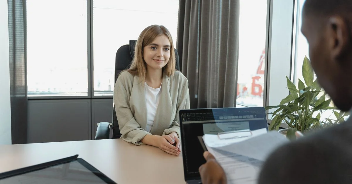 Jeune femme assise avec confiance dans un bureau moderne pour un entretien d'embauche.