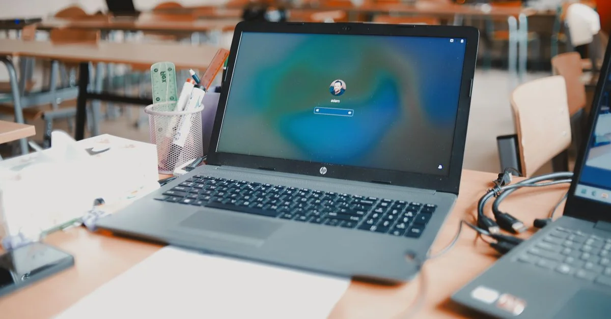 Gros plan sur un ordinateur portable sur un bureau dans un cadre de salle de classe, prêt à être utilisé pour l'éducation.