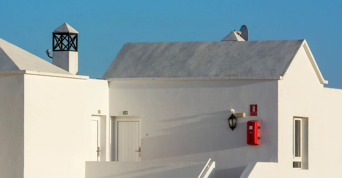 Extérieur moderne d'un bâtiment blanc avec un extincteur par une journée ensoleillée.