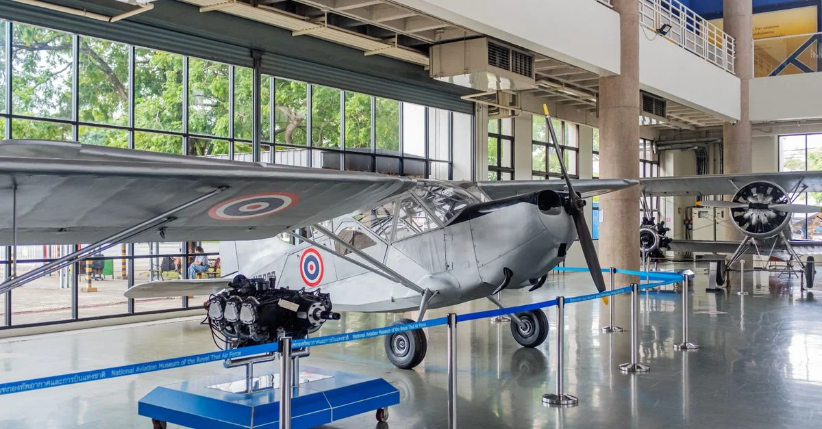 Exposition d'avions anciens dans un musée de l'aviation moderne aux intérieurs détaillés.