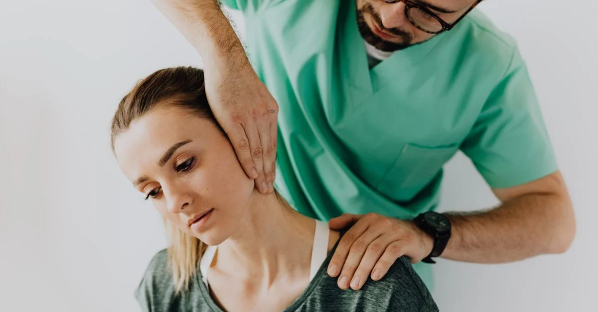 Chiropracteur effectuant un ajustement thérapeutique du cou sur une patiente pour soulager la douleur.