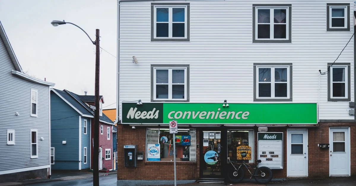 Vue de face d'un magasin de proximité situé dans un quartier urbain résidentiel.