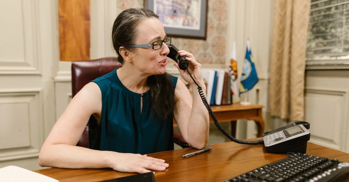 Une femme d'affaires en conversation téléphonique à son bureau dans un bureau.
