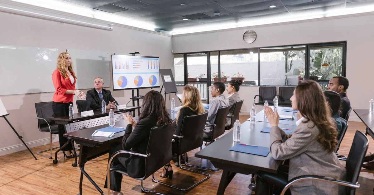 Des professionnels d'affaires assistant à une réunion dans une salle de conférence moderne.