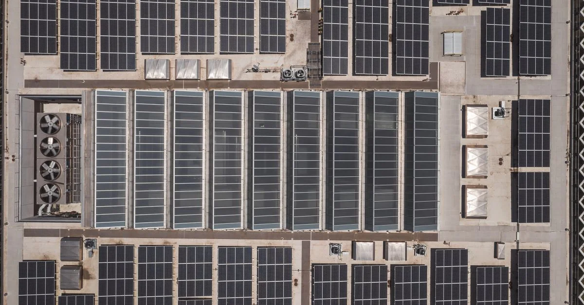 Prise de vue aérienne en hauteur de panneaux solaires sur un toit mettant en avant la technologie d'énergie renouvelable.