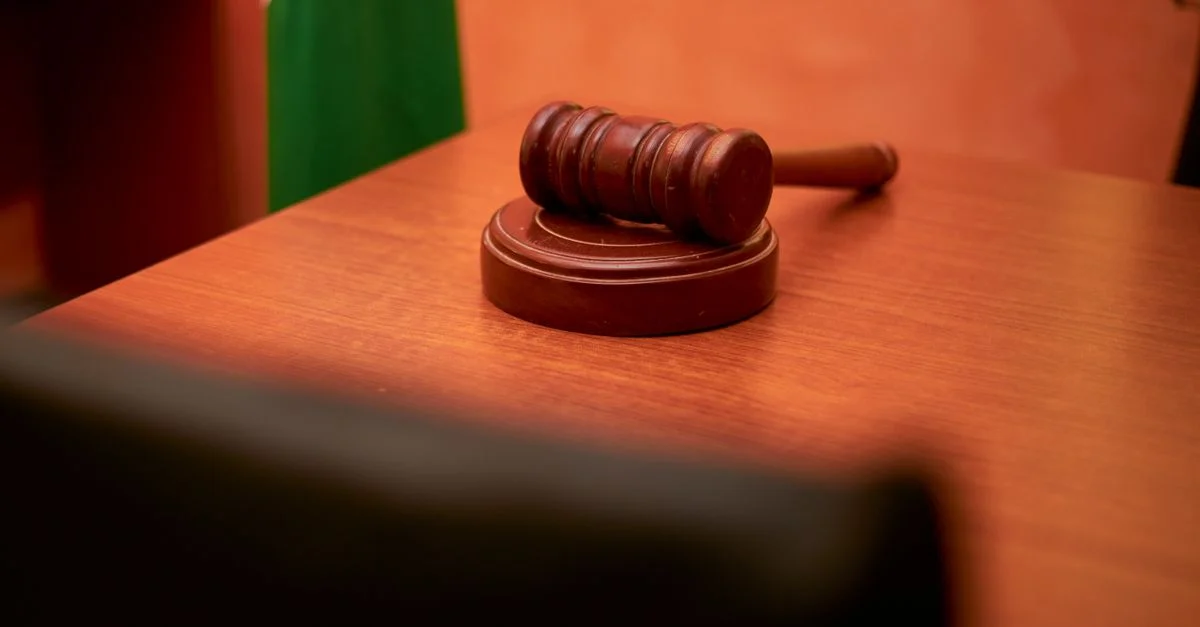 Gros plan d'un marteau sur un bureau de salle d'audience représentant le droit et la justice.