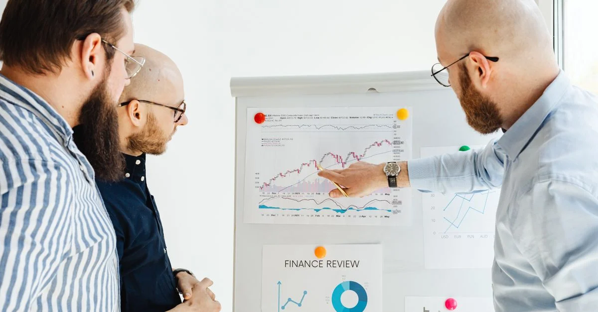 Équipe d'affaires examinant des graphiques financiers lors d'une réunion stratégique à l'intérieur.