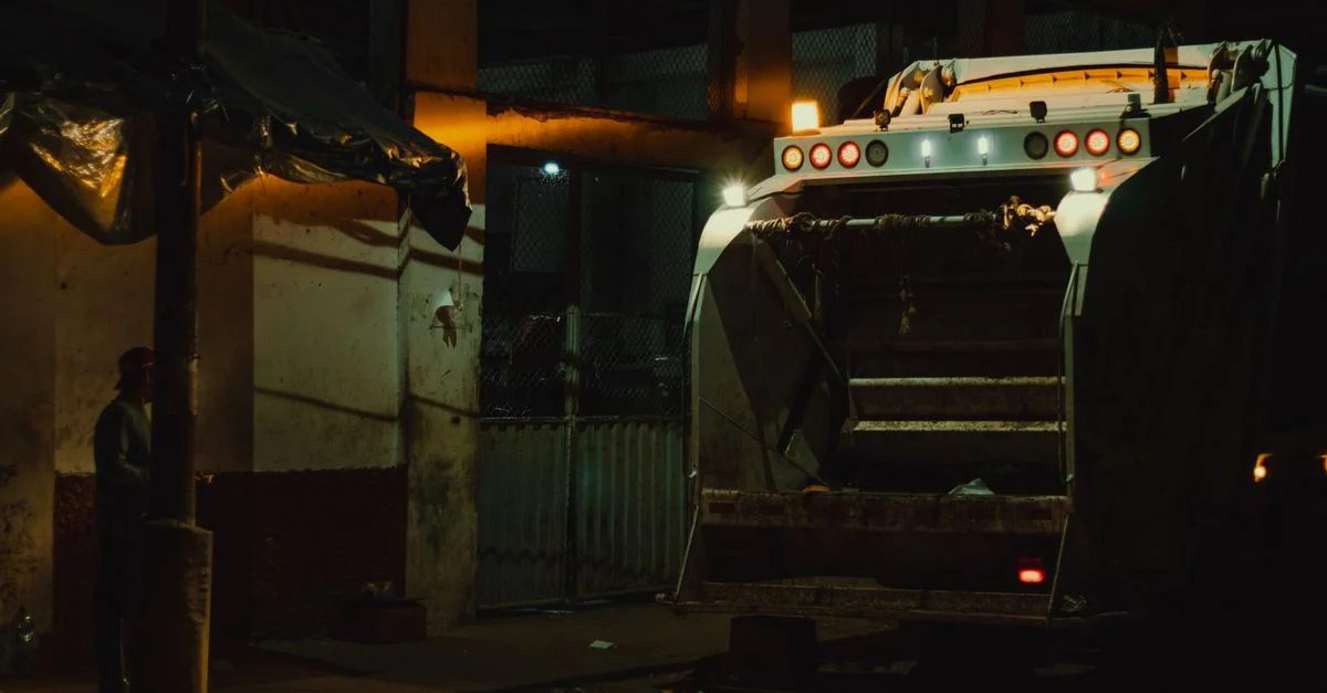 Camion à ordures la nuit sous les lumières de la ville à Yurimaguas, au Pérou.