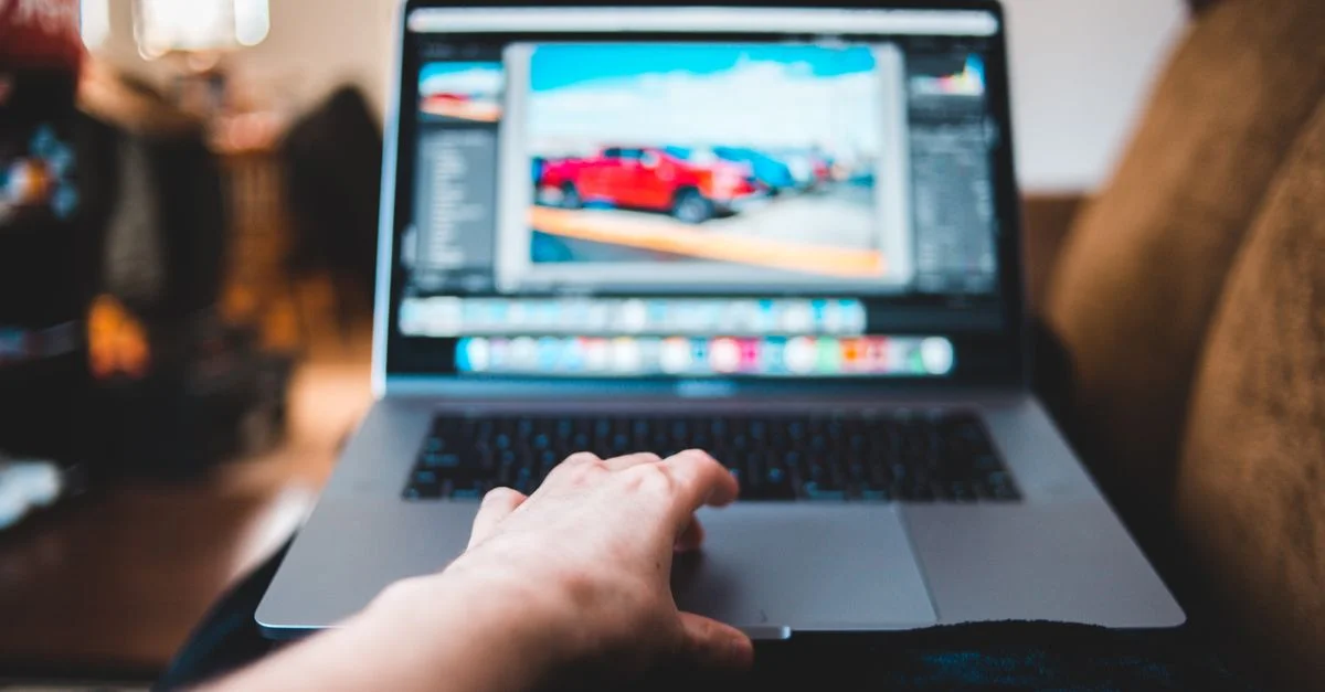 Une personne en train d'éditer des photos sur un ordinateur portable dans un cadre domestique confortable, adoptant un mode de vie moderne de freelance.
