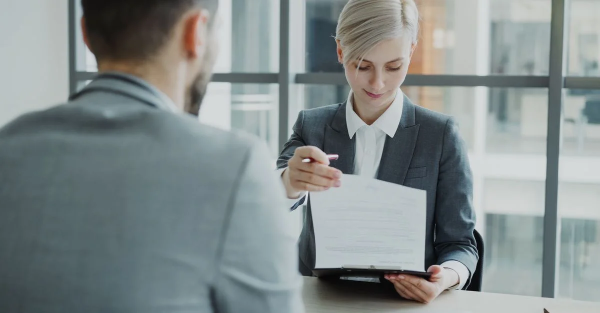 Des professionnels du monde des affaires révisent un contrat dans un environnement de bureau moderne.