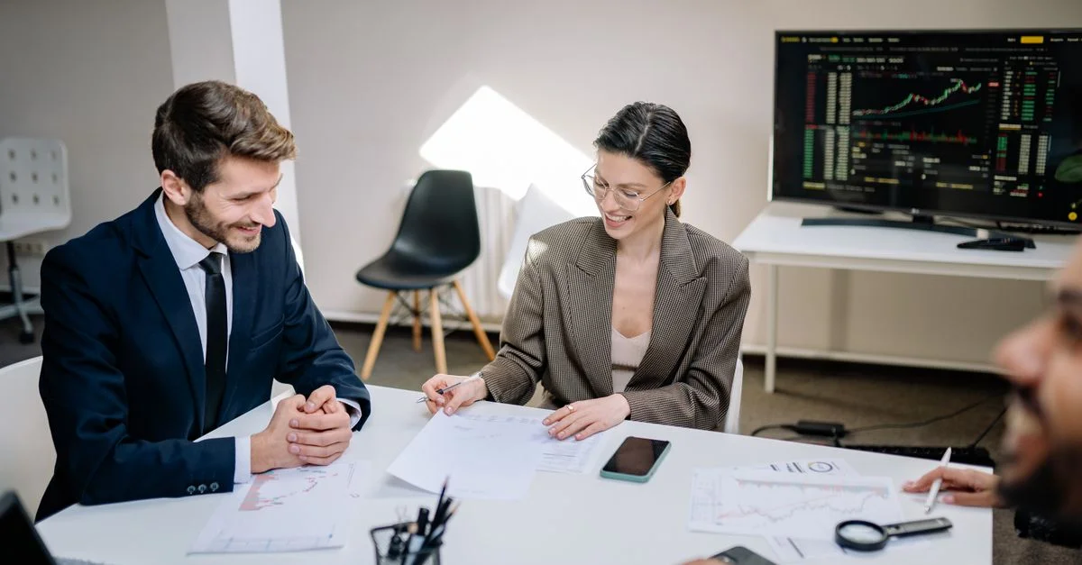 Des professionnels d'entreprise discutent de points de données et de graphiques lors d'une réunion de bureau.