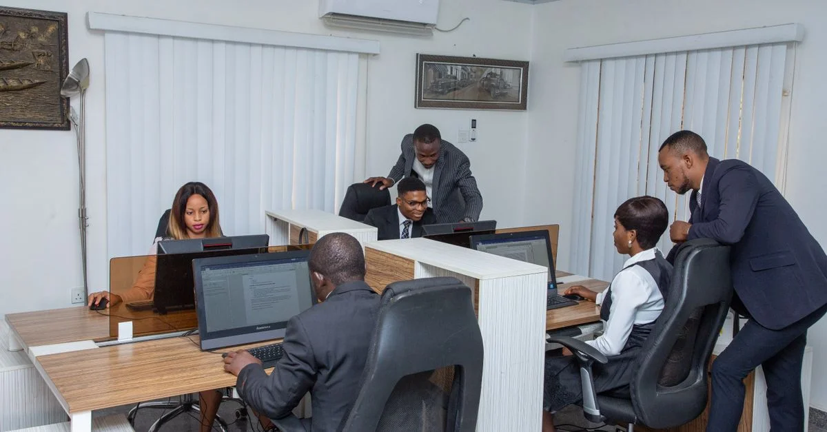 Un groupe de professionnels travaillant ensemble dans un bureau moderne, mettant en avant le travail d'équipe et la productivité.