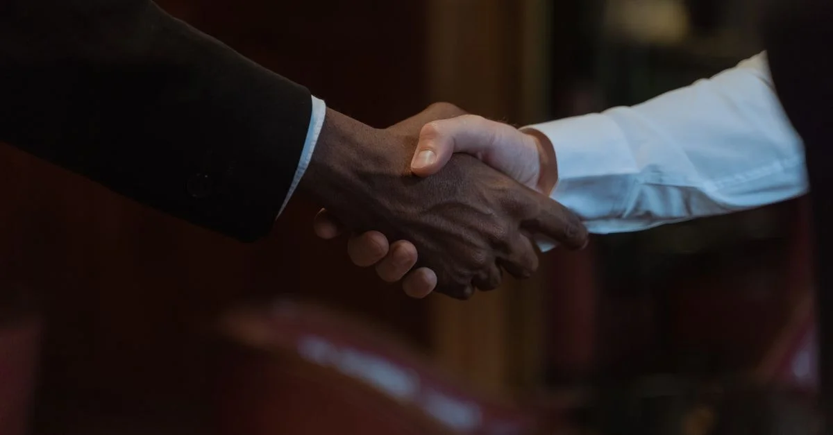 Gros plan sur une poignée de main diversifiée, représentant la collaboration business et la diversité.
